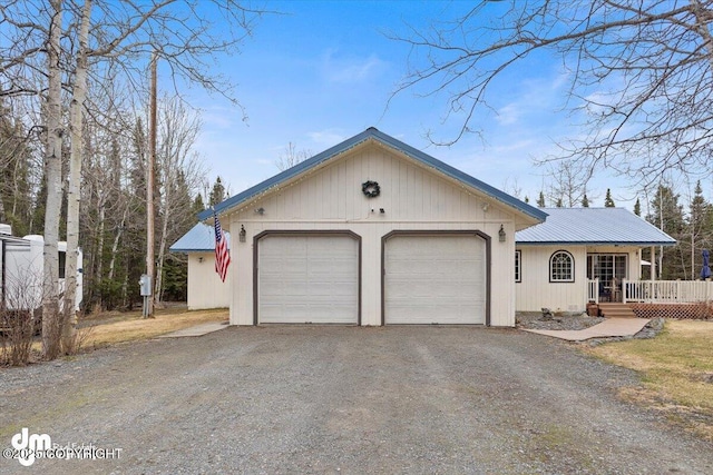 single story home featuring driveway, metal roof, and a garage