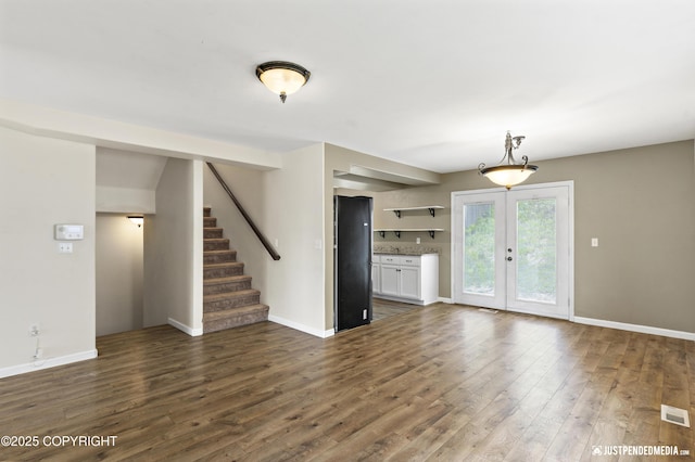 243 Creekside St # 2, Anchorage, AK 99504 - unfurnished living room featuring dark wood-type flooring, stairway, baseboards, and french doors