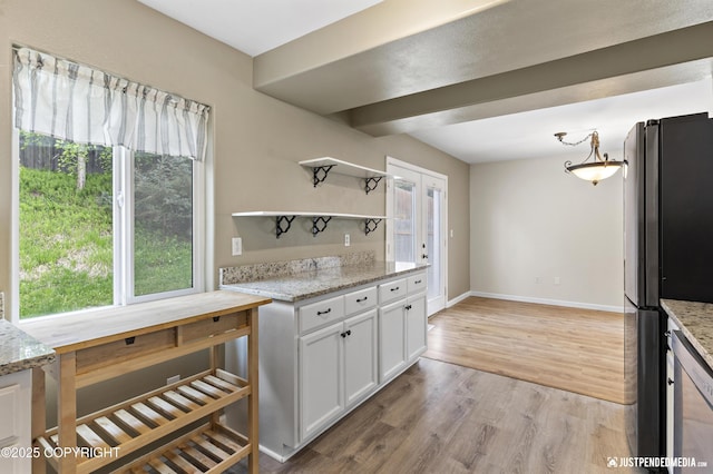 243 Creekside St # 2, Anchorage, AK 99504 - kitchen with freestanding refrigerator, open shelves, white cabinetry, light wood finished floors, and light stone counters