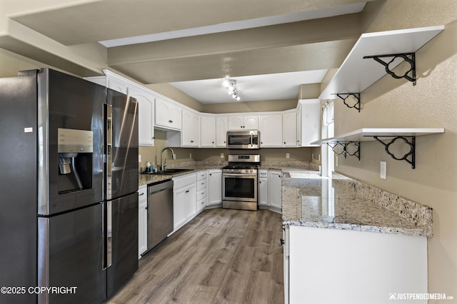 243 Creekside St # 2, Anchorage, AK 99504 - kitchen with appliances with stainless steel finishes, light wood-style flooring, white cabinetry, light stone counters, and a sink