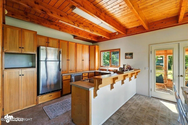 25925 Williamson Ln, Kasilof, AK 99610 - kitchen with stainless steel appliances, a peninsula, a wooden ceiling with exposed beams, a breakfast bar, and carpet floors