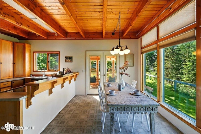 25925 Williamson Ln, Kasilof, AK 99610 - dining area featuring a chandelier, carpet flooring, and a wooden ceiling with exposed beams