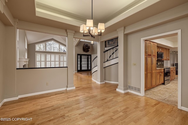 interior space featuring light wood-style floors, baseboards, and an inviting chandelier