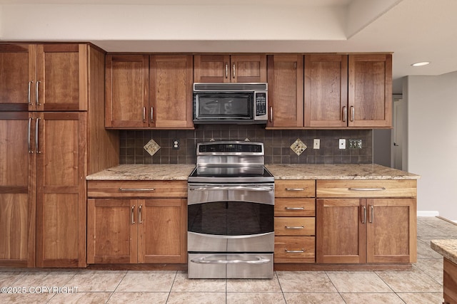 kitchen with backsplash, electric range, brown cabinets, and light tile patterned flooring