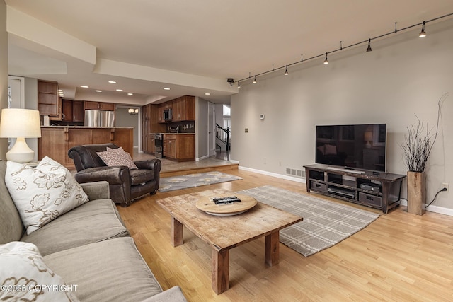 living area with visible vents, rail lighting, baseboards, recessed lighting, and light wood-style flooring