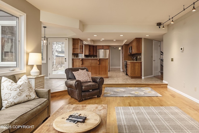 living room featuring light wood-style floors, baseboards, recessed lighting, and rail lighting