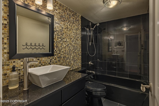 bathroom with tile patterned flooring, vanity, toilet, tile walls, and shower / washtub combination