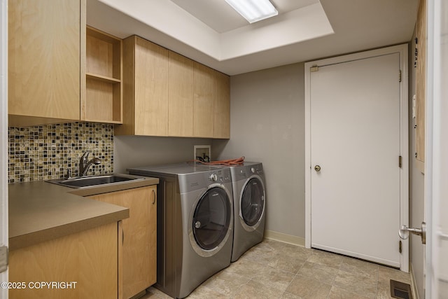 washroom featuring cabinet space, a sink, separate washer and dryer, baseboards, and visible vents