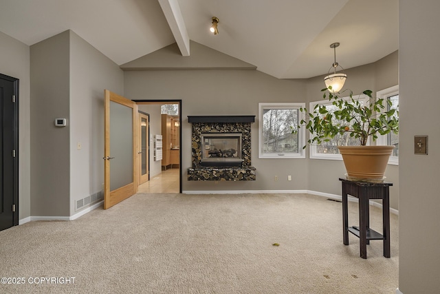 unfurnished living room featuring a healthy amount of sunlight, vaulted ceiling with beams, carpet, and visible vents