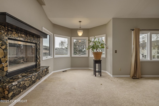 unfurnished living room with baseboards, visible vents, carpet, and a fireplace