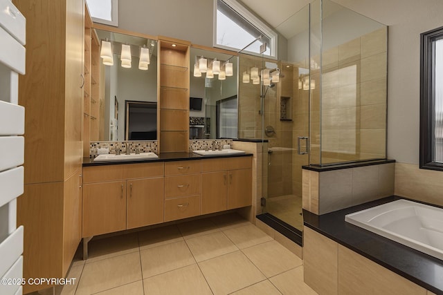 full bath with a sink, double vanity, tile patterned floors, a bath, and a stall shower