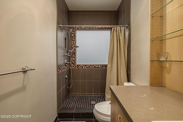 bathroom with vanity, toilet, and tiled shower
