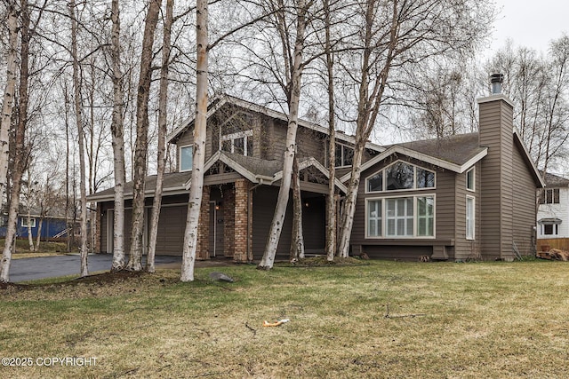 exterior space featuring a shingled roof, an attached garage, a chimney, a yard, and driveway