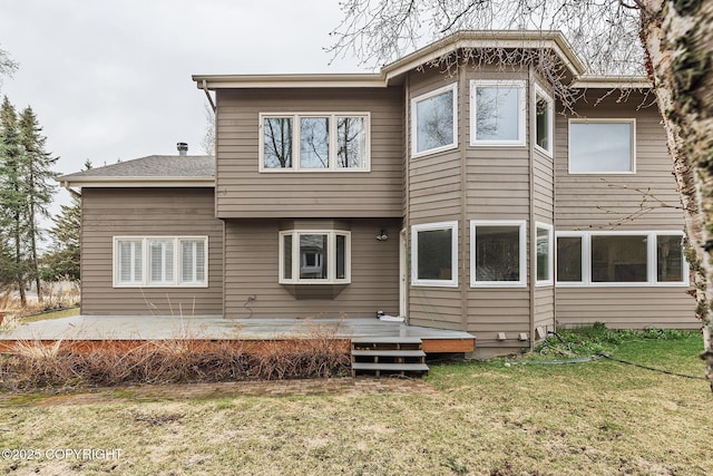 rear view of house featuring a lawn and a deck