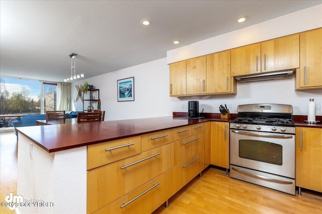 5201 E Northern Lights Blvd # 3N, Anchorage, AK 99508 - kitchen with a peninsula, light wood finished floors, dark countertops, stainless steel range with gas cooktop, and recessed lighting