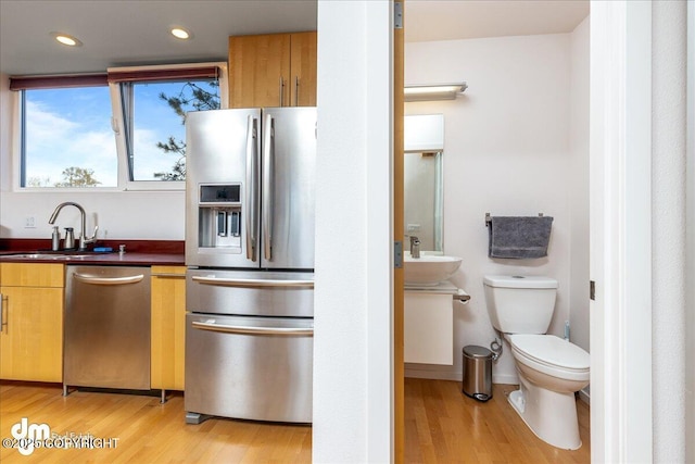 5201 E Northern Lights Blvd # 3N, Anchorage, AK 99508 - kitchen featuring a sink, stainless steel appliances, dark countertops, and light wood-style flooring