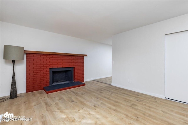 1523 Demeure Pl, Anchorage, AK 99508 - unfurnished living room featuring a brick fireplace, wood finished floors, and baseboards