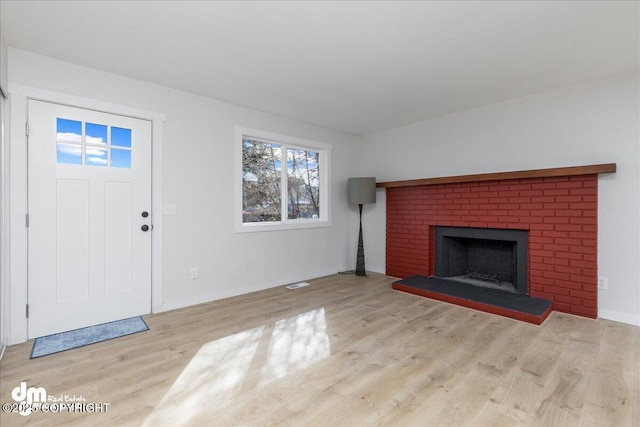1523 Demeure Pl, Anchorage, AK 99508 - unfurnished living room featuring visible vents, wood finished floors, and a brick fireplace