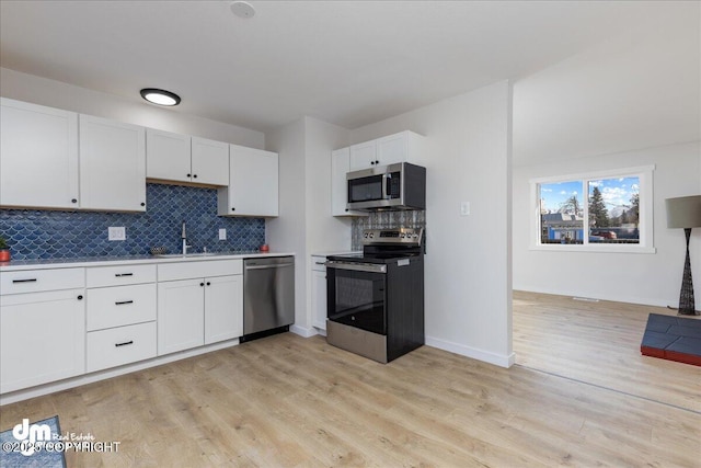1523 Demeure Pl, Anchorage, AK 99508 - kitchen with tasteful backsplash, appliances with stainless steel finishes, light countertops, white cabinetry, and light wood-type flooring