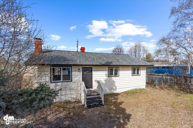 1523 Demeure Pl, Anchorage, AK 99508 - view of front of house featuring fence, roof with shingles, and a chimney