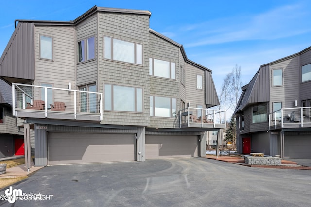 1741 W 15th Ave, Anchorage, AK 99501 - view of front of house featuring an attached garage, a balcony, and driveway