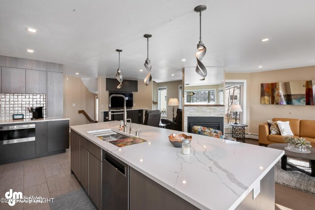 1741 W 15th Ave, Anchorage, AK 99501 - kitchen with modern cabinets, a fireplace, a baseboard radiator, open floor plan, and stainless steel appliances