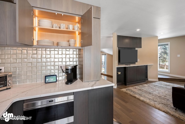 1741 W 15th Ave, Anchorage, AK 99501 - kitchen with dark wood-style flooring, light stone countertops, modern cabinets, stainless steel microwave, and backsplash