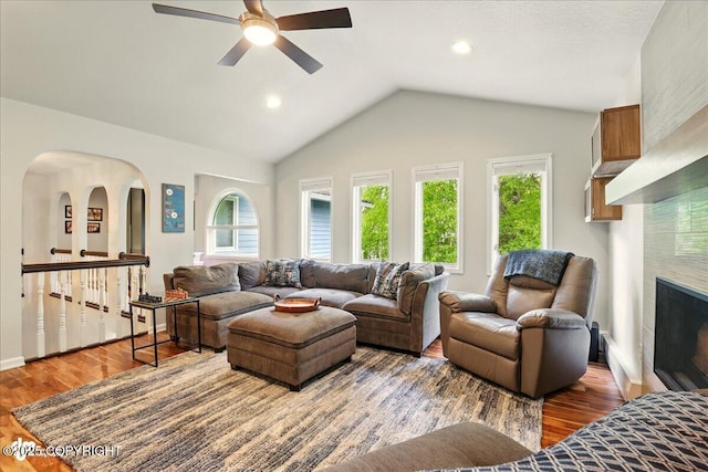 4200 Endeavor Cir, Anchorage, AK 99515 - living area with a ceiling fan, wood finished floors, vaulted ceiling, a large fireplace, and baseboards