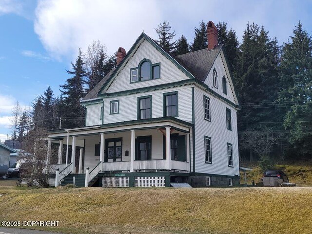 1 Fort Seward Dr, Haines, AK 99827 - view of front of property featuring a chimney, a porch, and a front yard