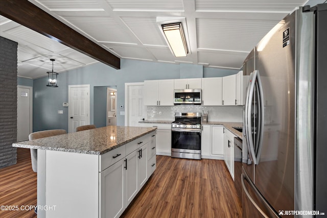 kitchen with appliances with stainless steel finishes, dark wood-type flooring, tasteful backsplash, and light stone counters