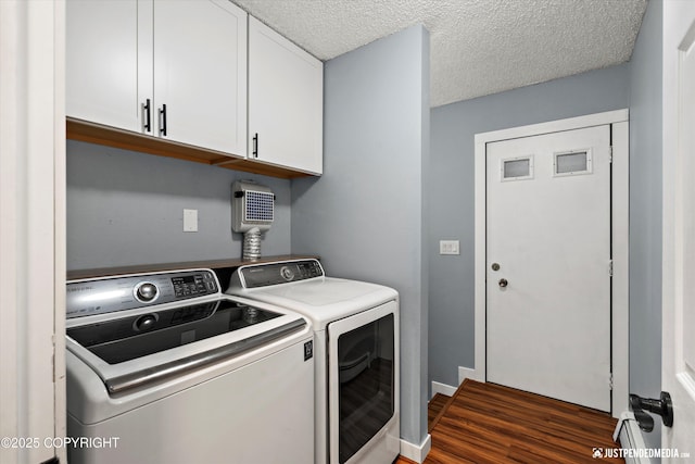 clothes washing area with independent washer and dryer, cabinet space, dark wood-type flooring, baseboards, and a textured ceiling