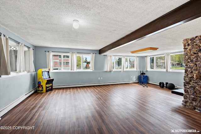 workout area featuring a textured ceiling, wood finished floors, a baseboard radiator, and baseboards