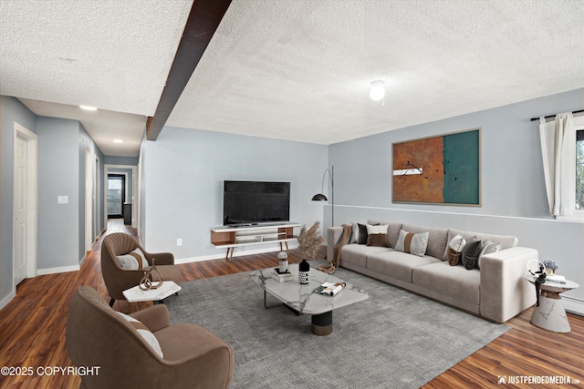 living area with a textured ceiling, wood finished floors, plenty of natural light, and baseboards