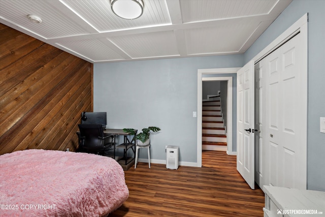 bedroom with dark wood-style flooring, baseboards, and a closet