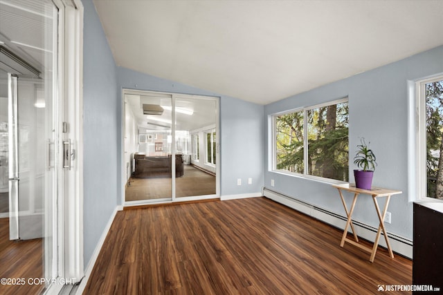 unfurnished room featuring baseboard heating, wood finished floors, lofted ceiling, and baseboards