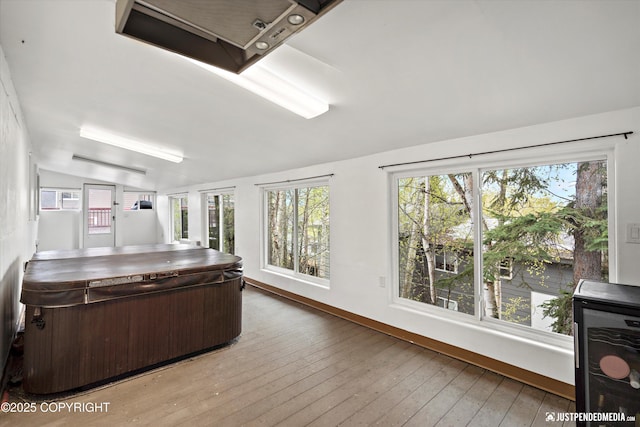 office area with vaulted ceiling, baseboards, and hardwood / wood-style floors