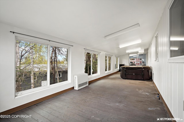sunroom with a hot tub and heating unit