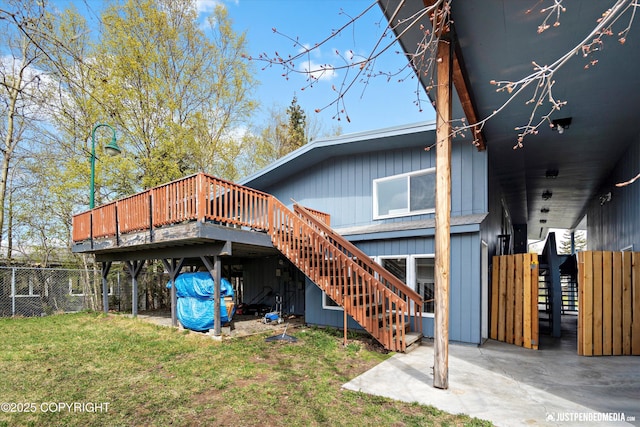 back of house featuring stairs, a wooden deck, and a patio area