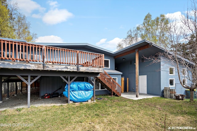 back of property featuring stairs, a deck, a lawn, and central AC