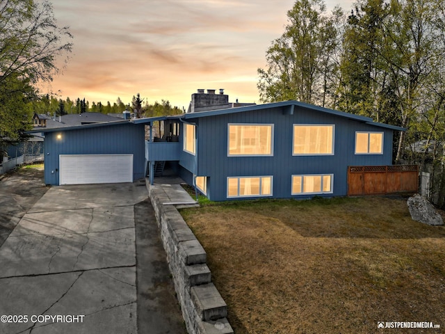 view of front of home with an attached garage, concrete driveway, and a chimney