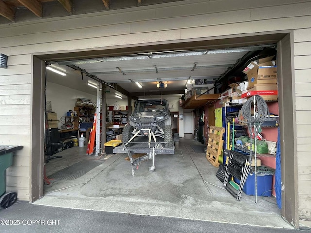 garage featuring a garage door opener and wooden walls
