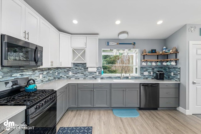 885 Soundview Ave, Homer, AK 99603 - kitchen with a sink, light wood-style floors, stainless steel gas range, dishwasher, and gray cabinets
