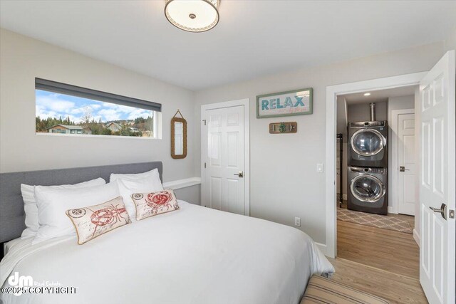 885 Soundview Ave, Homer, AK 99603 - bedroom featuring baseboards, stacked washer and dryer, and light wood-style flooring
