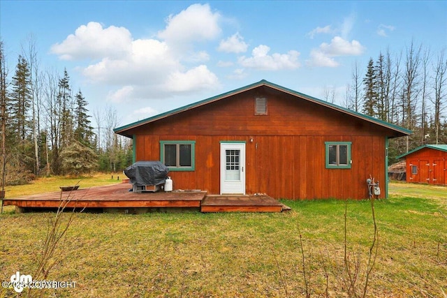 back of house with a wooden deck and a lawn
