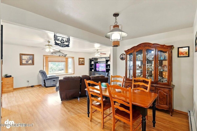 dining space with a ceiling fan, light wood-style floors, a baseboard heating unit, and baseboards