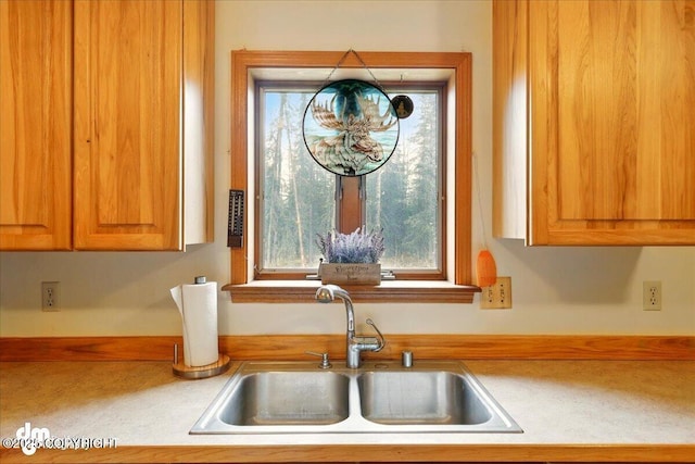 kitchen view of a sink and light countertops