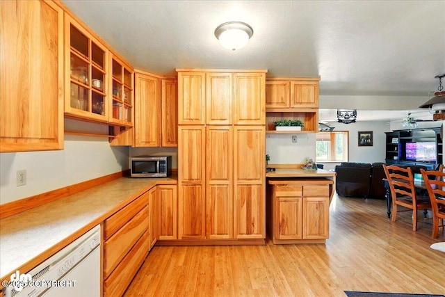 kitchen with stainless steel microwave, white dishwasher, open shelves, light wood-type flooring, and light countertops