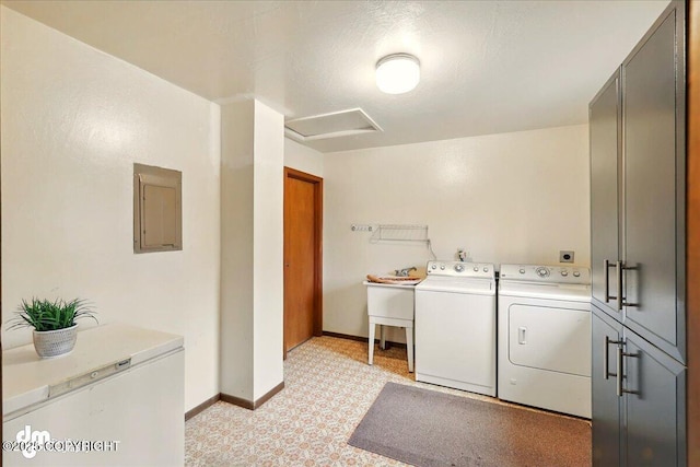laundry room featuring washer and clothes dryer, electric panel, cabinet space, attic access, and baseboards