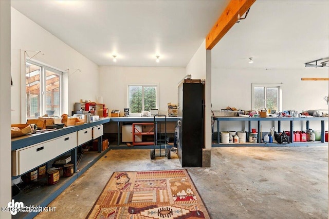 kitchen featuring concrete flooring, plenty of natural light, open floor plan, and beam ceiling