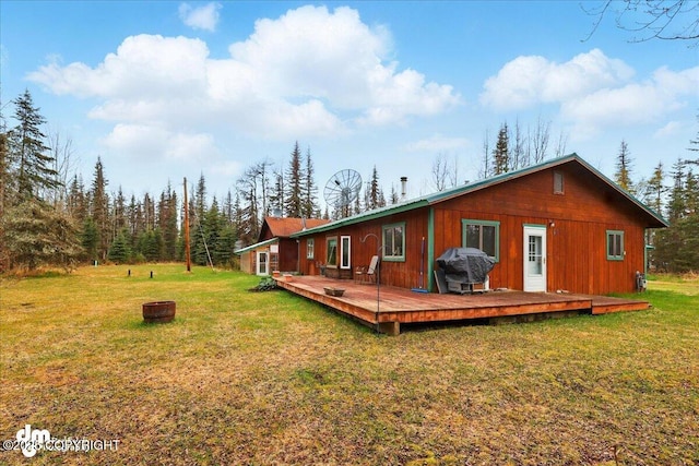 back of property featuring a deck and a lawn